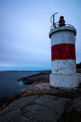 Lighthouse on cliff in the Baltic sea archipelago in Sweden during sunrise, vertical
