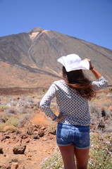 Atrakcyjna młoda kobieta patrzy na wulkan Teide na Teneryfie
