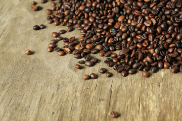 Aromatic coffee beans scattered on wooden background