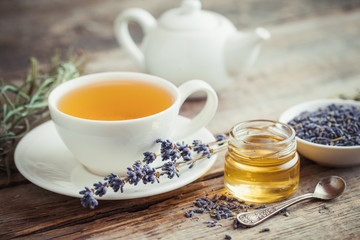 Healthy tea cup, jar of honey, dry lavender flowers and teapot o