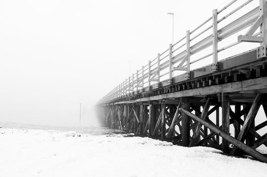 Fototapeta Wooden scary bridge disappearing in the fog. Bridge leading to nowhere.