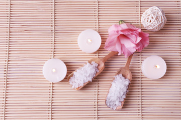 Spa composition of candles, soap, sea salt and flower on bamboo background