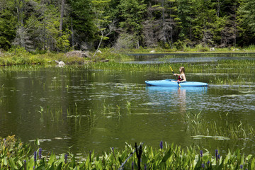Young woman in kayak on Mud Pond in Sunapee, New Hampshire, horizontal. © duke2015