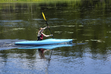 Young woman in kayak on Mud Pond in Sunapee, New Hampshire, horizontal.