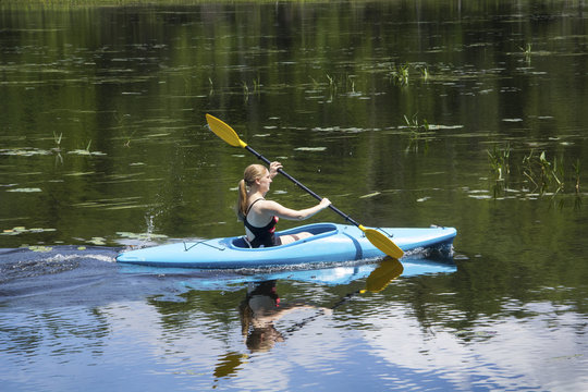 Young woman in kayak on Mud Pond in Sunapee, New Hampshire, horizontal.