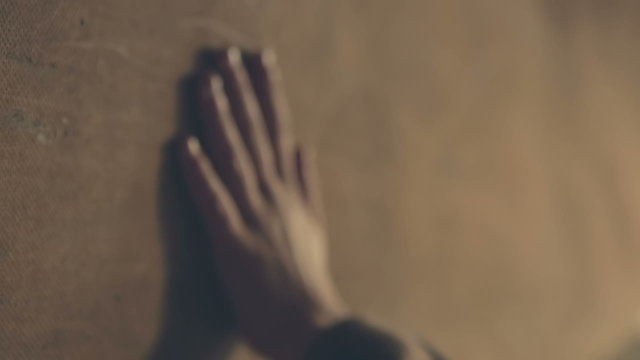 Hand touches the young master of plywood on the wall