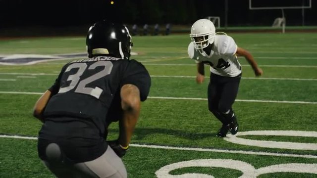 A football player runs down the field and catches the ball and runs for a touchdown