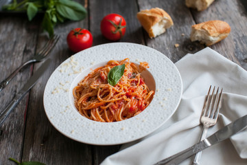 Italian pasta with tomatoes and cheese on old table