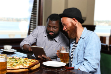 Young men drinking beer and talking in cafe