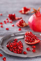 Juicy pomegranates,whole and broken vintageon a metal plate.selective focus.