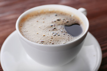 Cup of coffee on wooden background