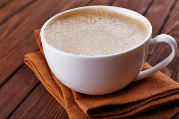 Cup of coffee on brown napkin closeup