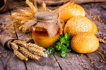 Honey in a jar, slice of bread, wheat and milk on an old vintage