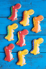 Homemade gingerbread cookie in the shape of dinosaurs on a woode