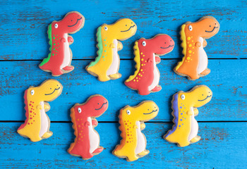 Homemade gingerbread cookie in the shape of dinosaurs on a woode