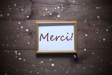 Golden Picture Frame With Merci Means Thank You And Snowflakes