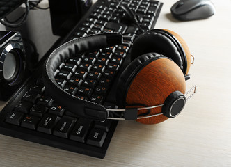 Obraz na płótnie Canvas Headphones and keyboard on wooden table