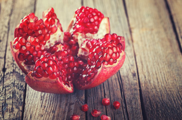 Ripe pomegranate fruit on wooden background.Toned image. Vintage style.selective focus.