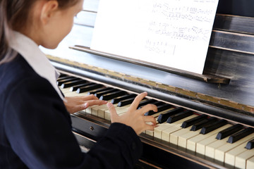 Attractive little girl plays piano