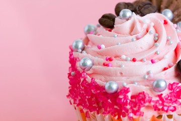 Cupcake with pink frosting, closeup.