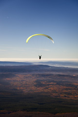 Yellow paragliding on plain with fall colors