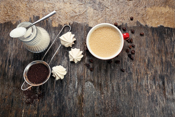 Cup of coffee with sweets on wooden background