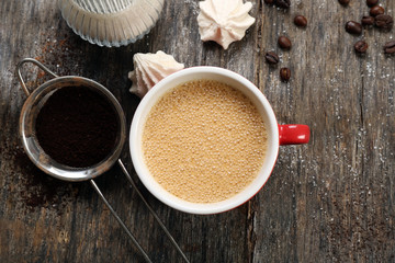 Cup of coffee with sweets on wooden background