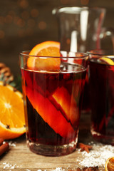 Decorated composition of mulled wine in glasses on wooden table, close up