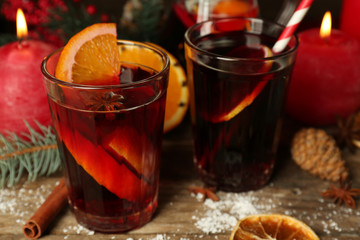 Decorated composition of mulled wine in glasses on wooden table, close up