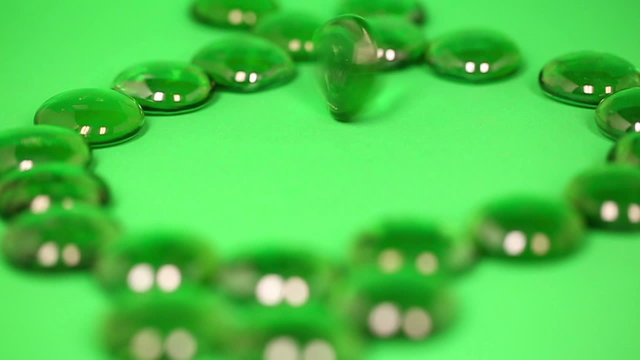 Spinning Green Gem. 3 shots of a hand spinning a green gem in slow motion
