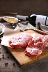 Marbled beef steak with bottle of wine and spices on wooden background