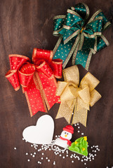 Christmas Decoration, snowman and ribbons on wooden background