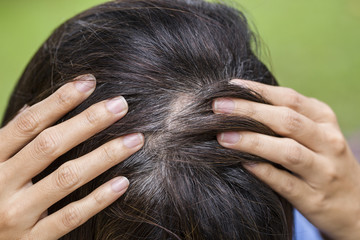 Young woman shows her gray hair roots