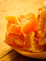 Closeup root and candied ginger on wooden table