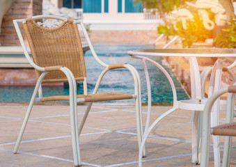 chairs and tables next to swimming pool