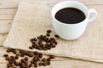 Cup of coffe on a sack with beans.