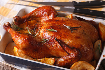 baked chicken with oranges and apples in the baking dish close-up. 
