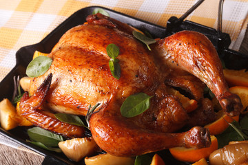 chicken roasted with oranges and apples closeup in a pan. horizontal
