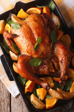 chicken roasted with oranges close-up in a pan. vertical top view
