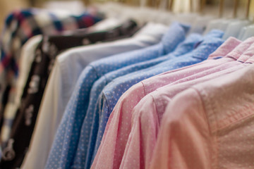 Fototapeta na wymiar blue and pink polka dot shirt hanging on a hanger