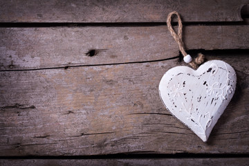 Decorative heart on aged wooden  background.