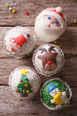 Fototapeta premium Christmas cupcakes closeup on a wooden table. vertical top view