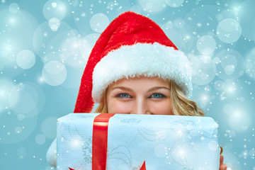 Girl dressed in santa hat with a Christmas gift 