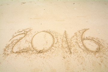 Year 2016 written on sand
