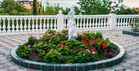 Terrace with flowerbeds and garden sculpture in the southern city