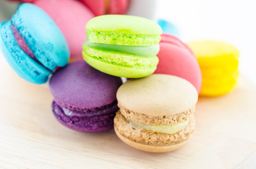 Colorful macaroons in white cup.