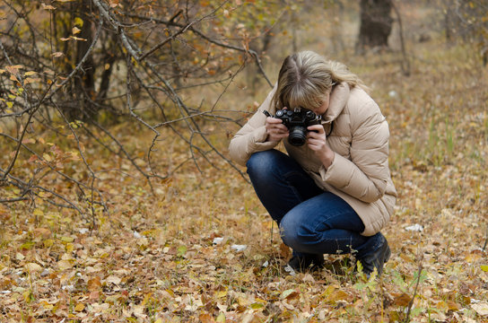 Woman photographer in the fall makes macro shots