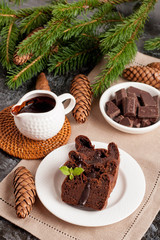 Fototapeta na wymiar Chocolate muffin with holiday decorations on a dark background
