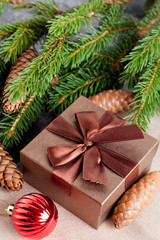 Fototapeta na wymiar brown gift box, Christmas ball and Green fir branches on black b