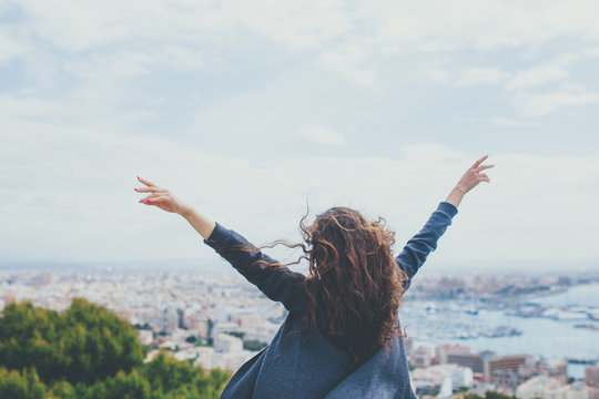 Back View Of Cheerful Young Woman With Hands Up. Freedom Concept.